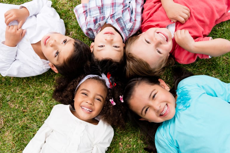 Happy group of kids lying on the floor in a circle-2